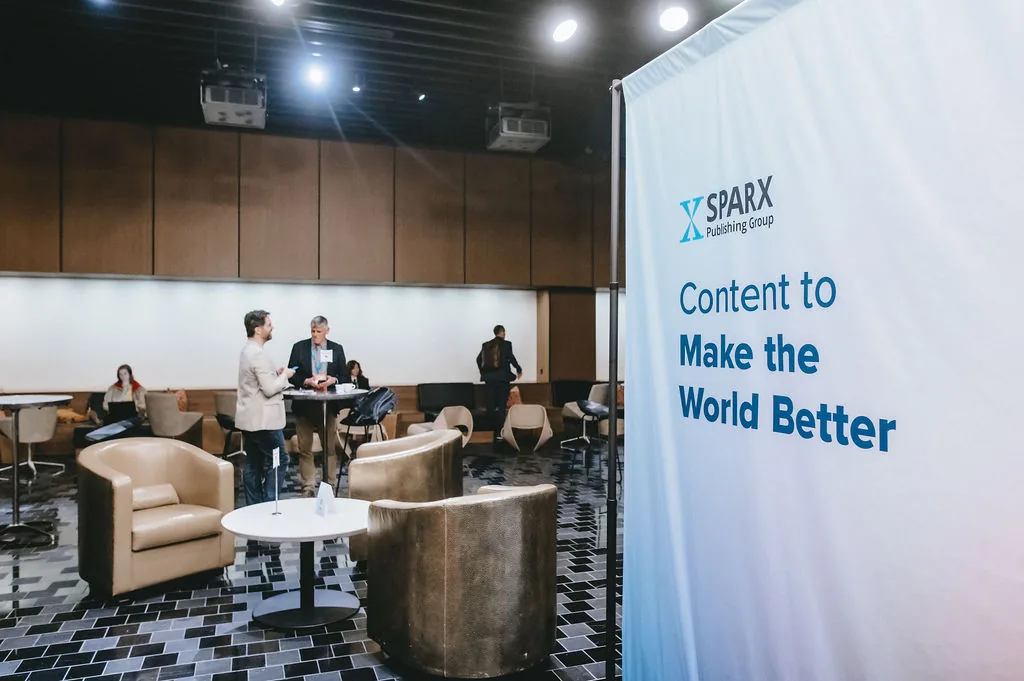 A banner reading Content to Make the World Better beside the Sparx Publishing Group logo, with attendees chatting at an event lounge